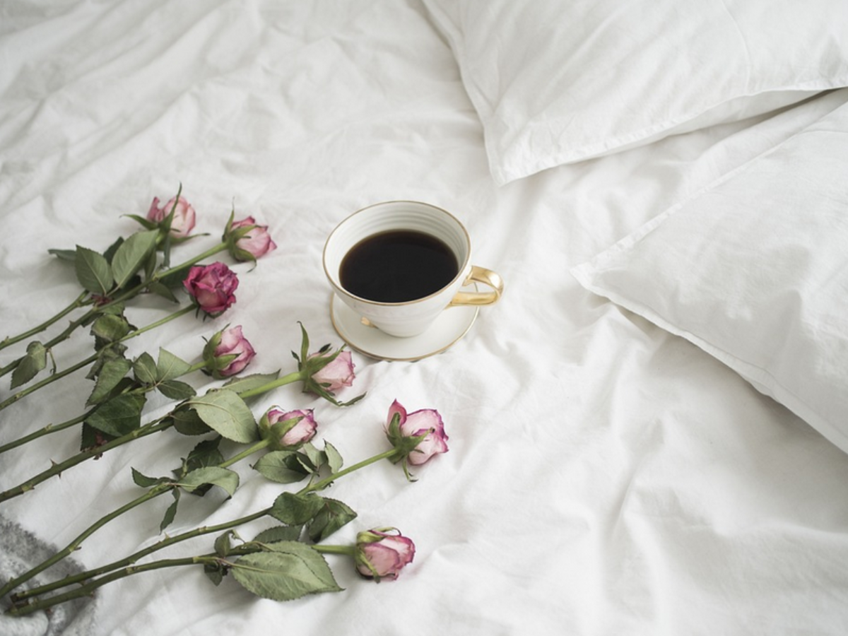 bed with coffee and flowers